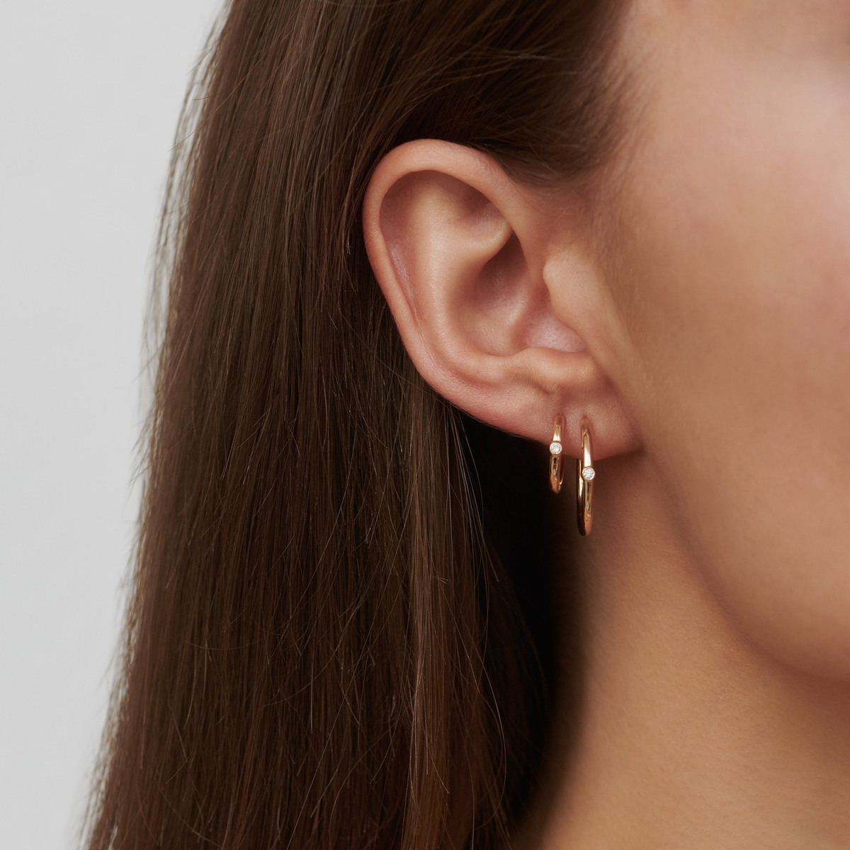 Modell bærer to Purity Medium Hoop creoler med diamant i ørene