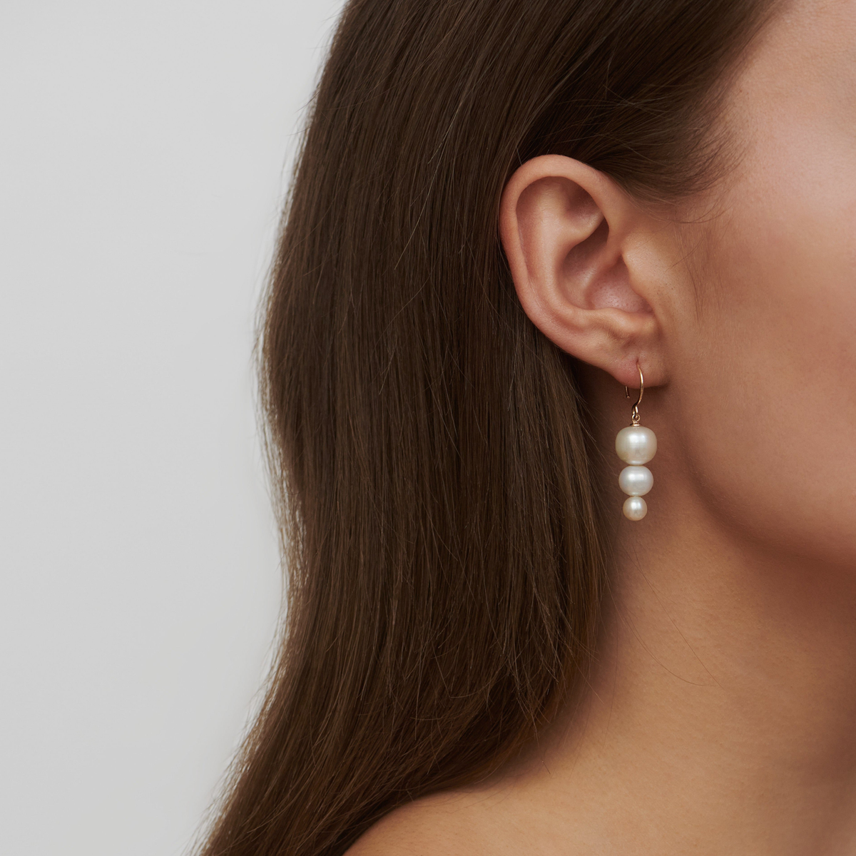 Modell med Eden Earring i øret, closeup av øre og hals