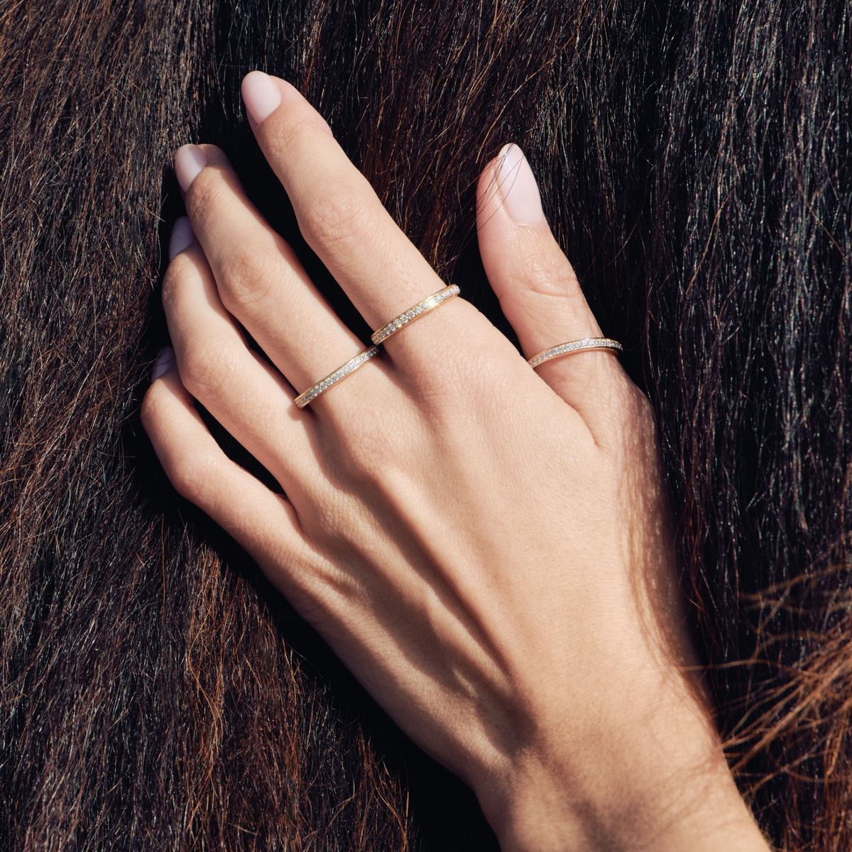 Elegance Band vist på hånd, stablet med flere tynne diamantringer