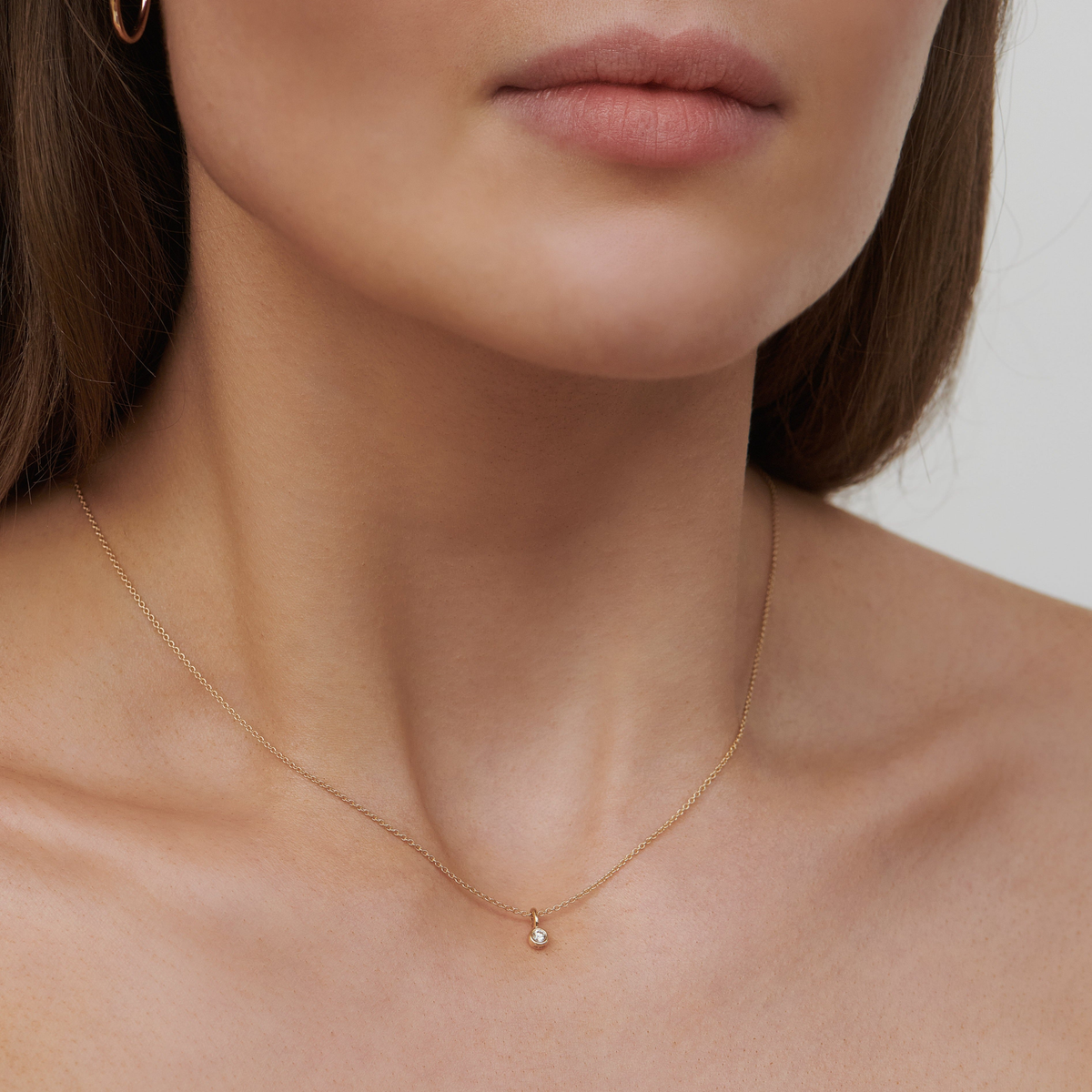 Modell bærer Purity anheng i 14K gull med diamant om halsen