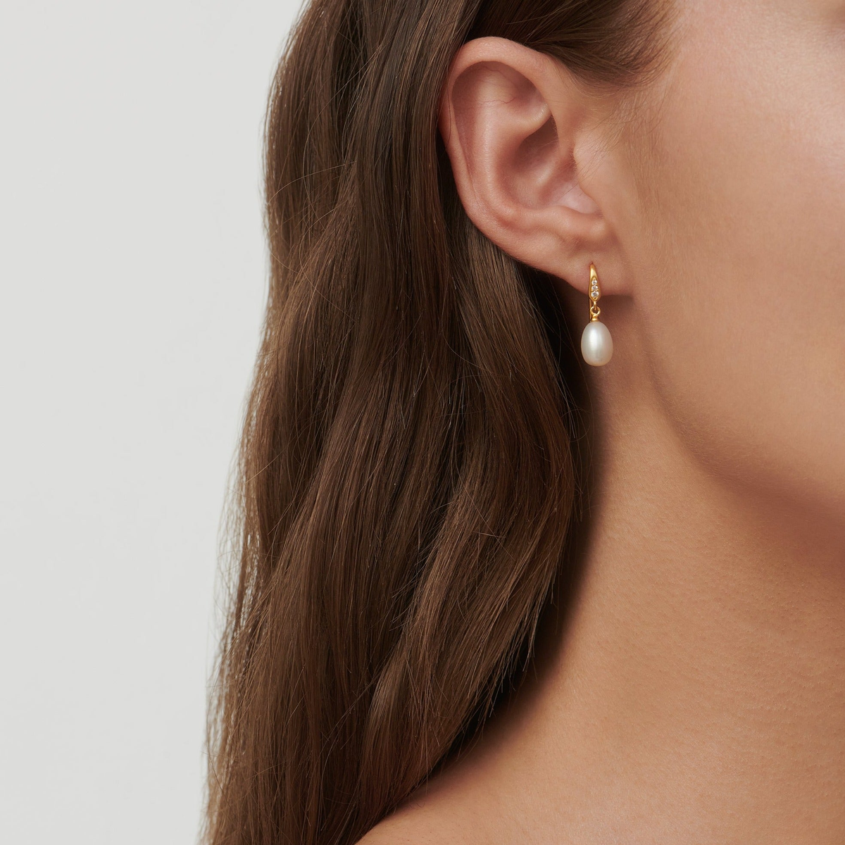 Modell bærer Ocean Earrings med ferskvannsperle, nærbilde av øret