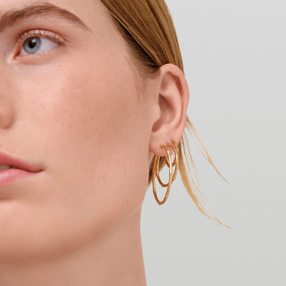 Modell iført lagvise Bamboo Hoops i 14K gull, tett på