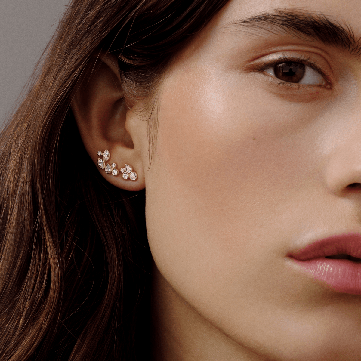 Modell har på seg Treasure Look i øret som et samlet ear climber-look med klyngesatt zirkonia i forgylt sølv