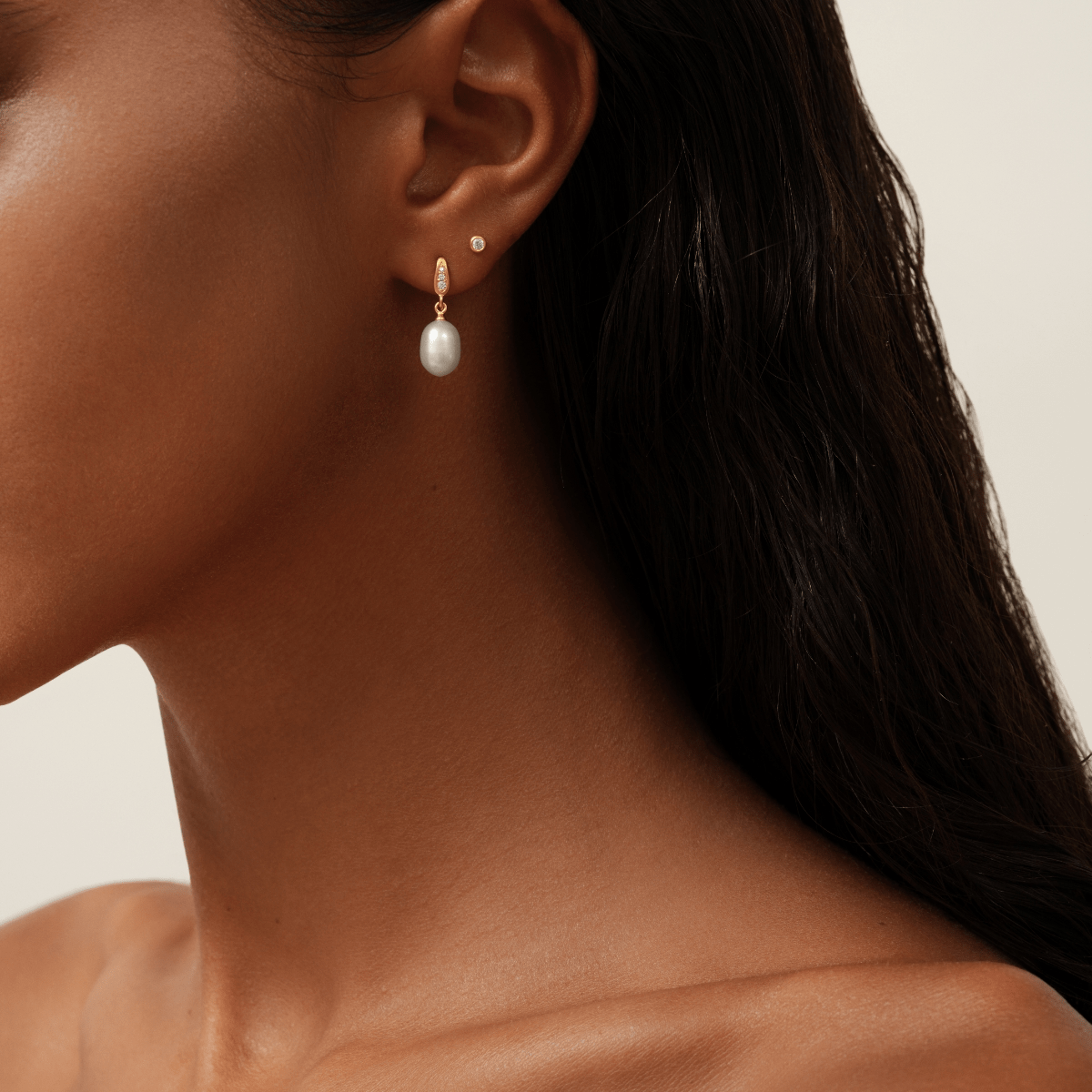 Modell bærer Ocean Earrings med ferskvannsperle, samt en ekstra liten kreol i samme øre