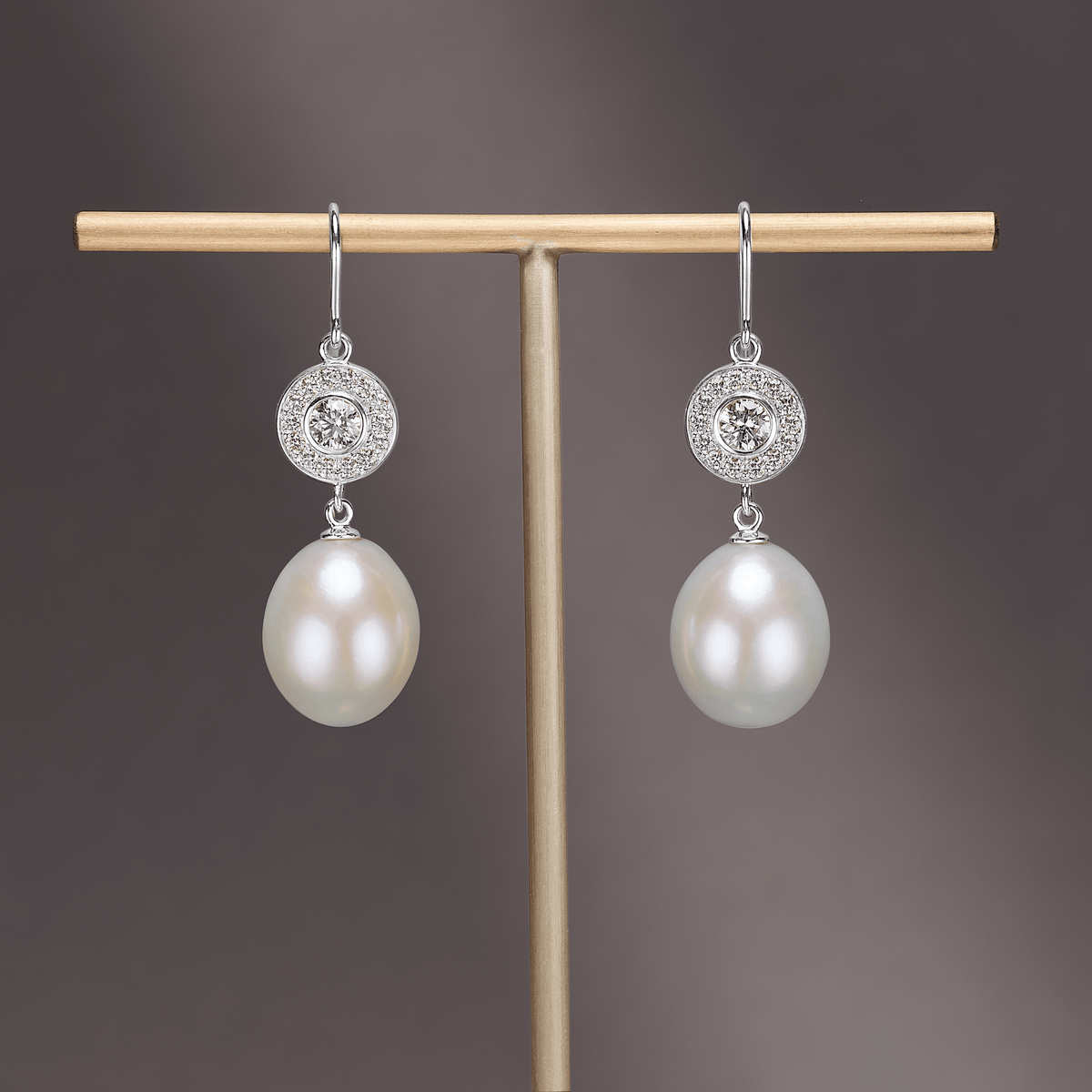 Heritage Earrings i 18 kt hvitt gull med diamant-halo og avtakbar perledråpe, stillfoto på smykkestativ
