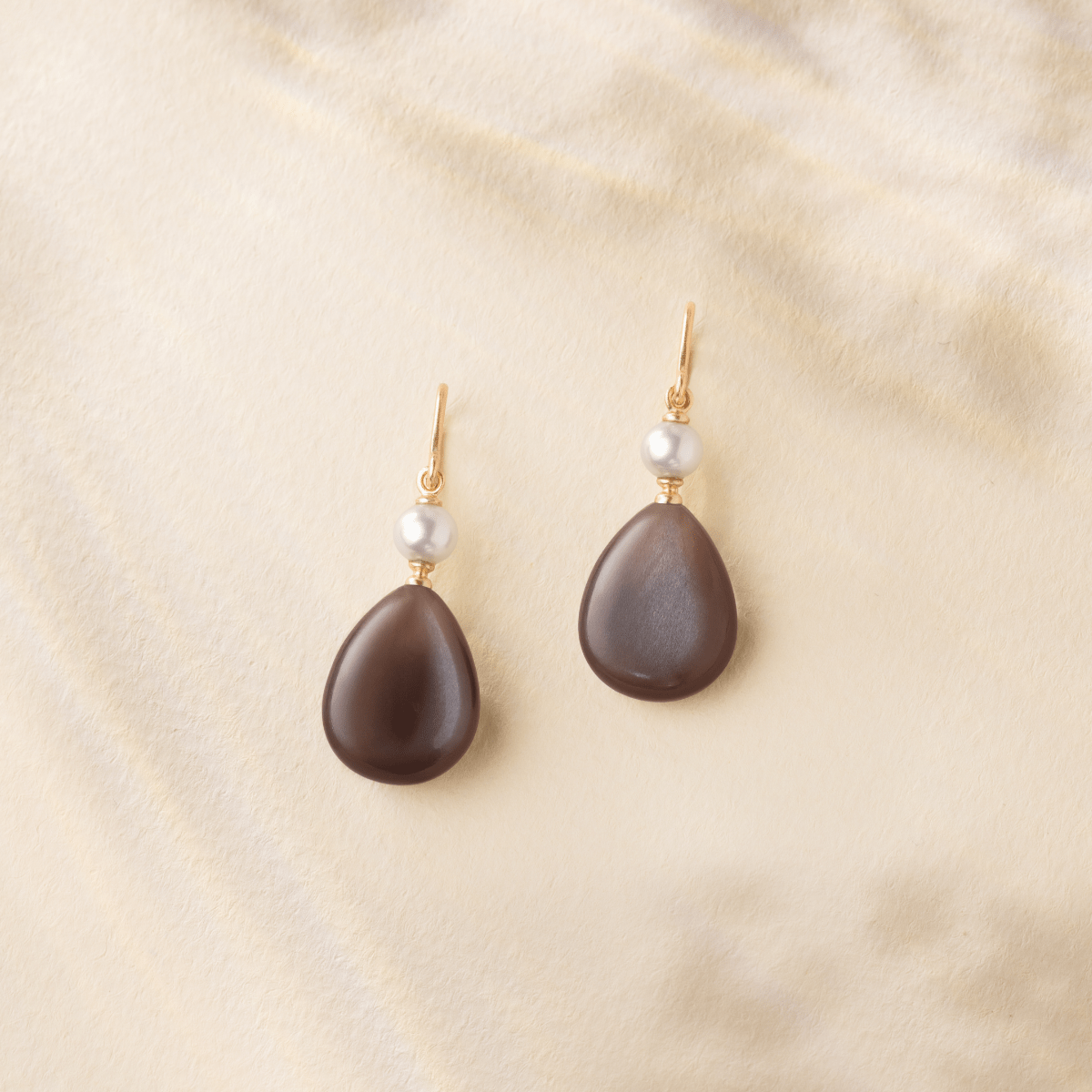 Elina Earrings stylet på modell, diamantstud synlig ved øret sammen med lagdelte halskjeder