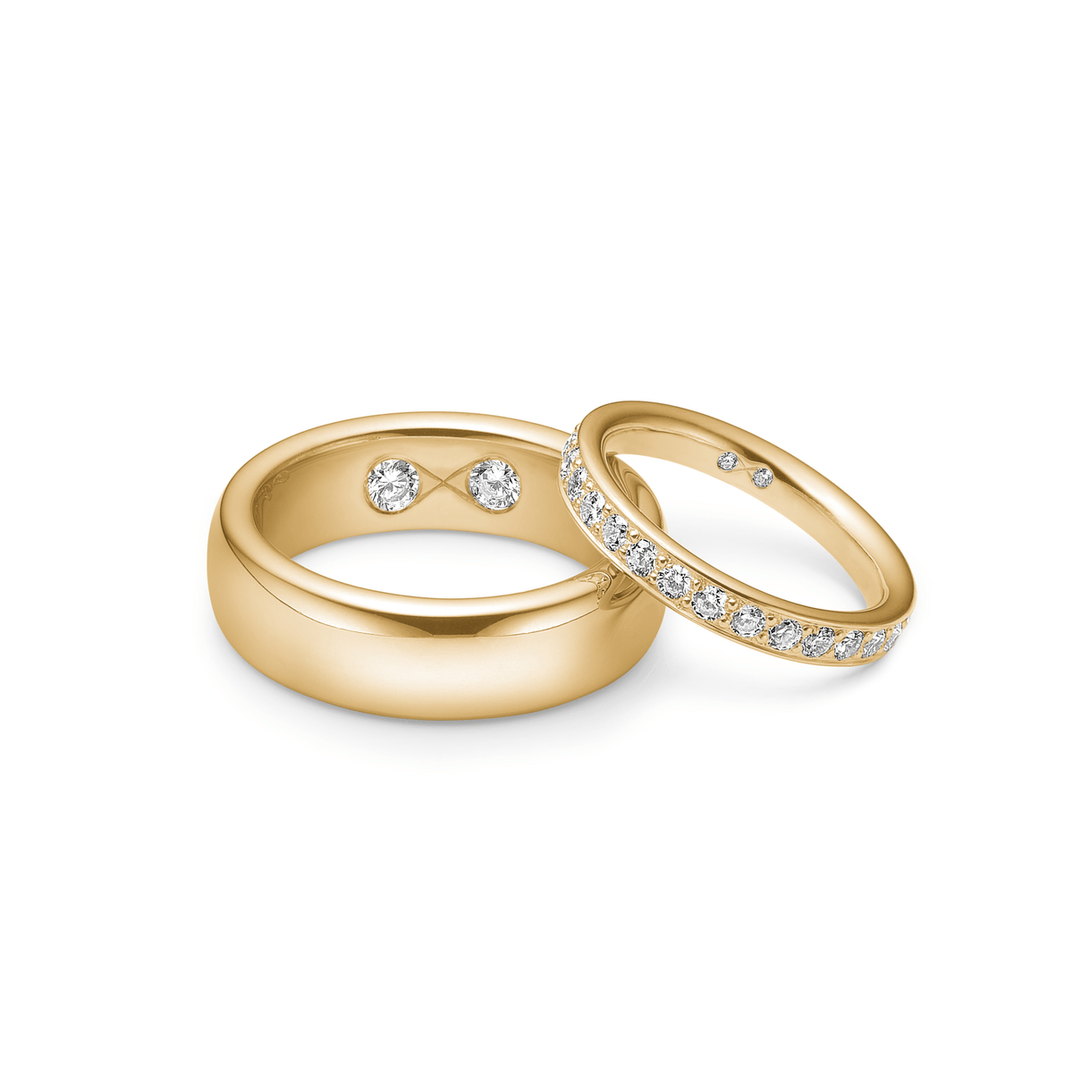Herrevielsesring fra Julie Sandlau i gull ved siden av en diamantbesatt damering fra samme Wedding-kolleksjon