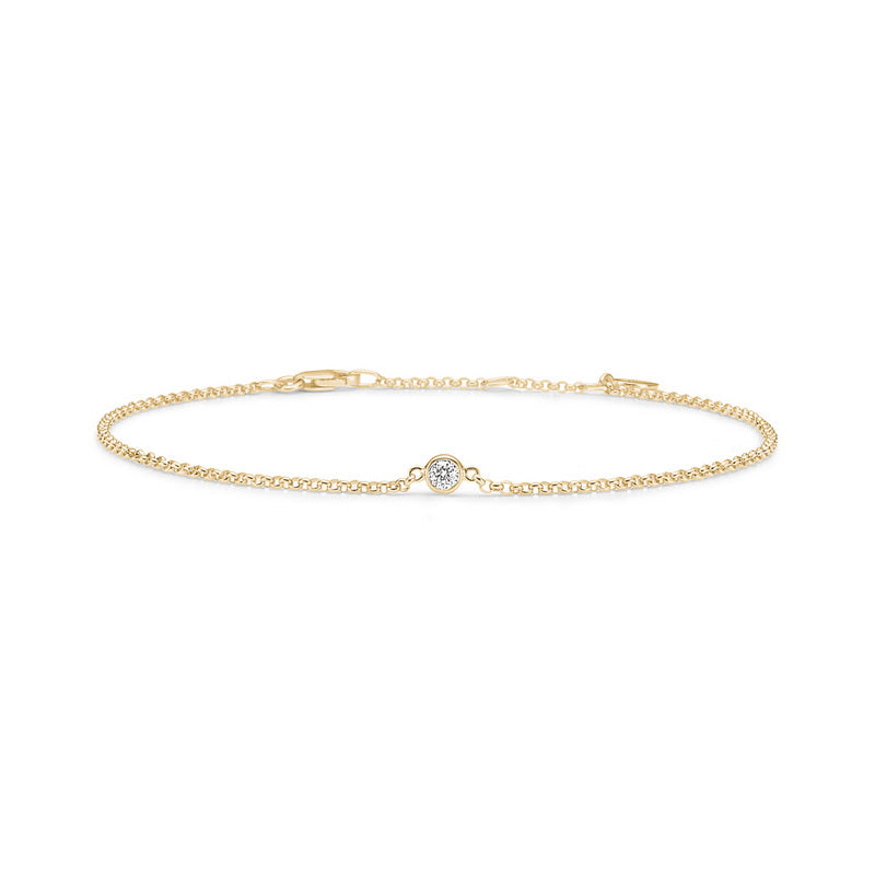 Fina armbånd i gull med bezelfattet diamant midt på kjedet